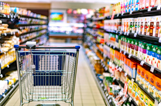 a shopping cart by a store shelf in a supermarket